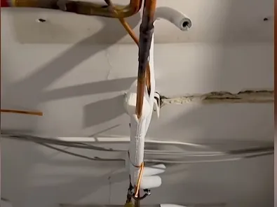 Construction site: copper and PVC service lines run across a ceiling with no coordinated route.