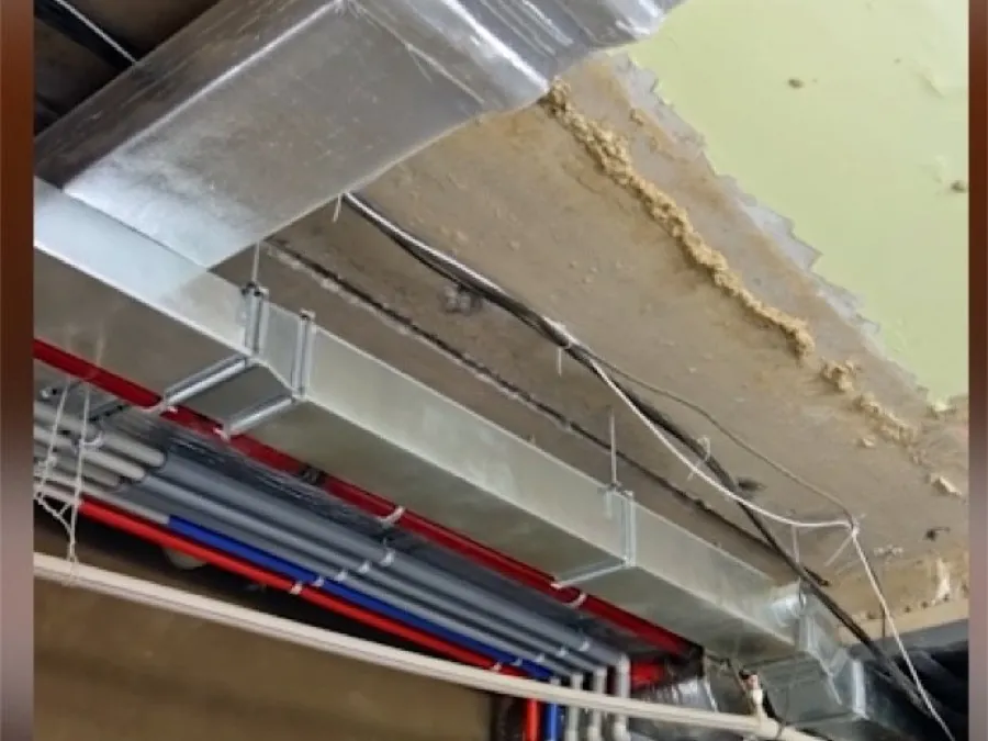 Construction site: a duct run passing under a structural beam with no clearance left for the ceiling.